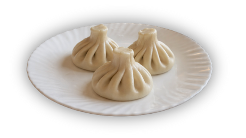 Trys koldūnai ant baltos keraminės lėkštės